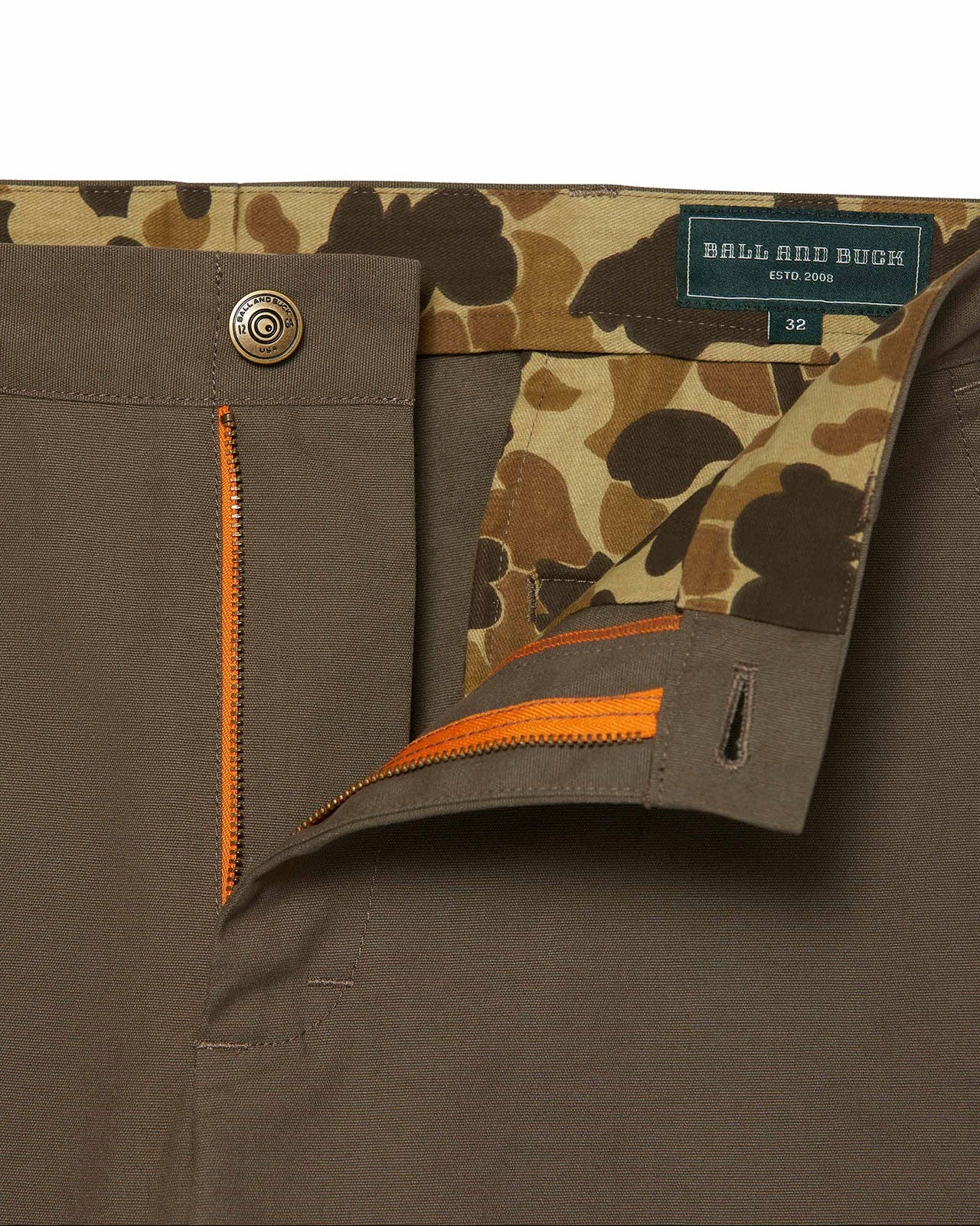 Brown pants with camouflage lining and orange zipper, featuring a brand label.