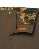 Brown pants with camouflage lining and orange zipper, featuring a brand label.