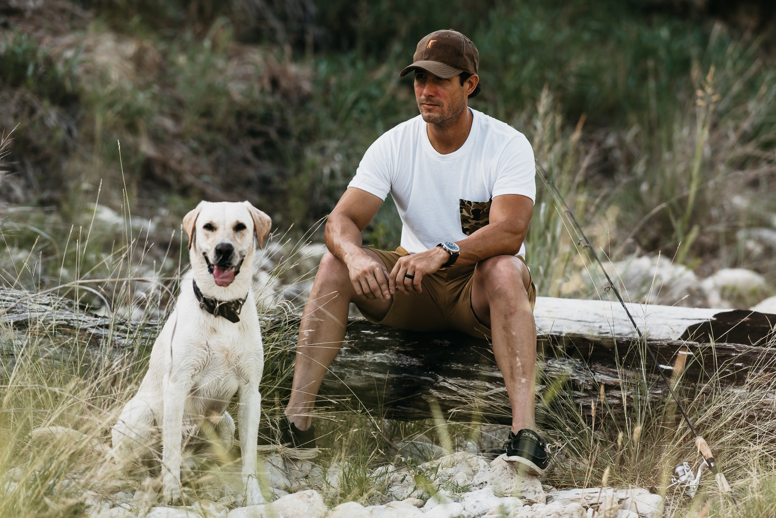 Man and dog sitting on a log in a natural setting