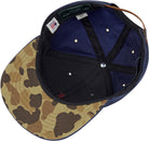 Camouflage-patterned cap with a blue interior and visible brand label.