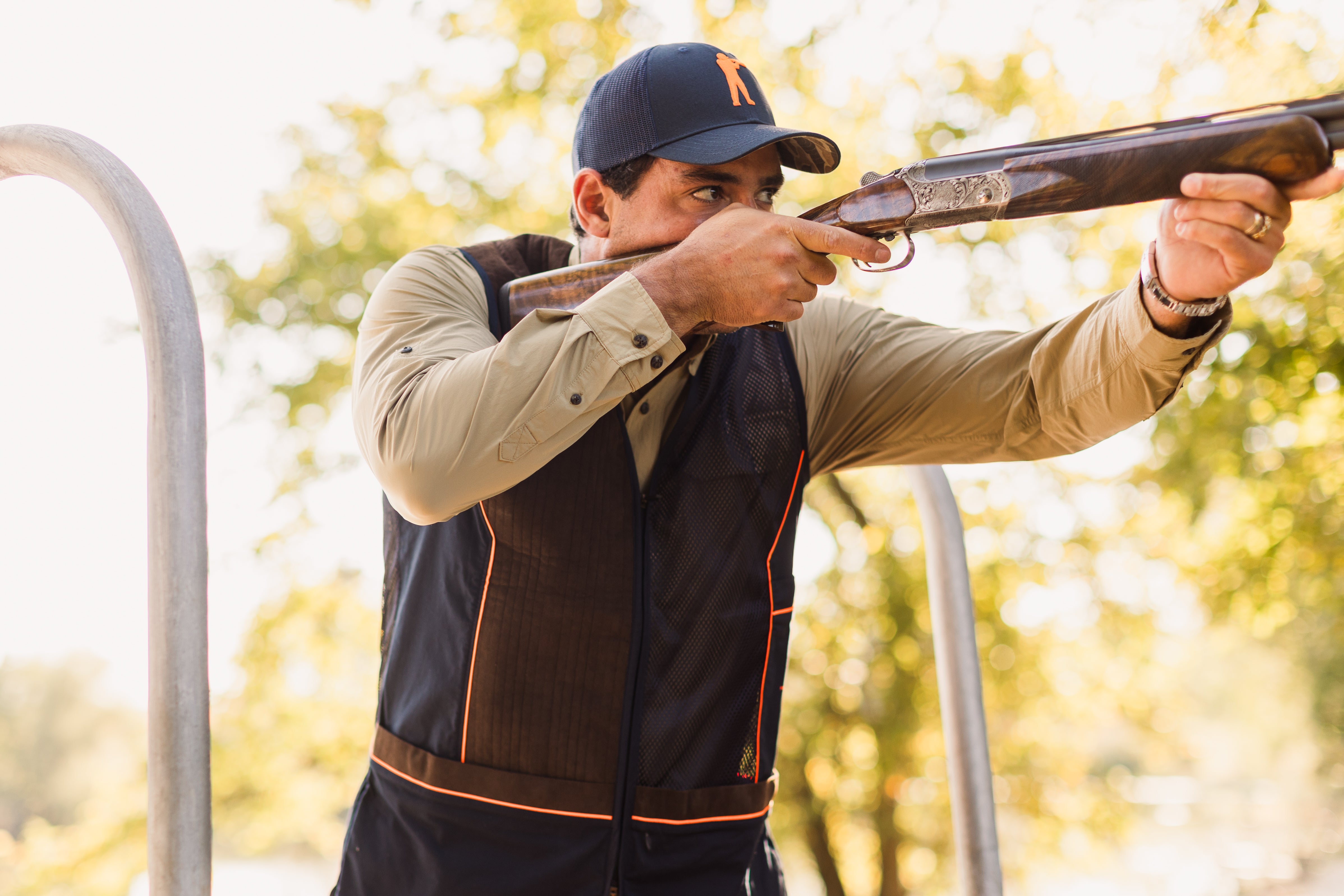 Man in outdoor setting holding a shotgun